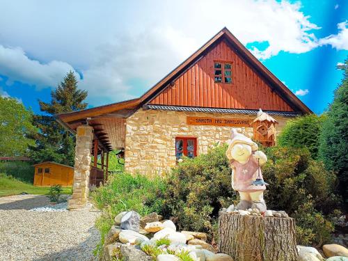 a statue in front of a house with a building at Chalet d' amour in Kamenný Újezd