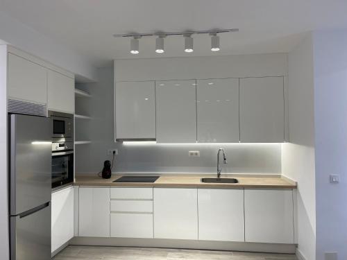 a white kitchen with a sink and a refrigerator at Apartamento a 50 metros de la Plaza del Charco, Puerto de la Cruz in Puerto de la Cruz