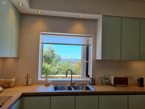 a kitchen with a sink and a window at Villa Katrin in Pylos