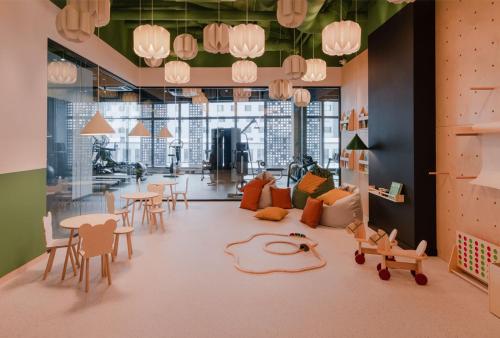 a living room with tables and chairs and a room with windows at Apartament City Spa - Sokolska 30 Towers in Katowice