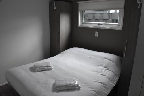 a bed in a room with two towels on it at Chalet ‘Het Giethoornsche Meer’ (16) in Giethoorn