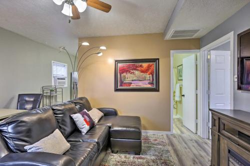 a living room with a leather couch and a table at Council Bluffs Cottage Proximity to Parks! in Council Bluffs