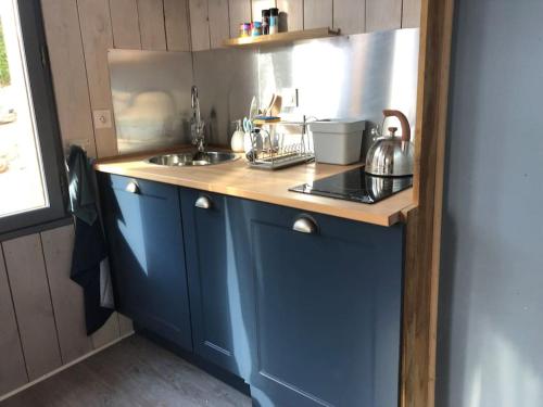 a blue kitchen with a sink and a counter at Adorable petite maison sur Loire à vélo in Villandry