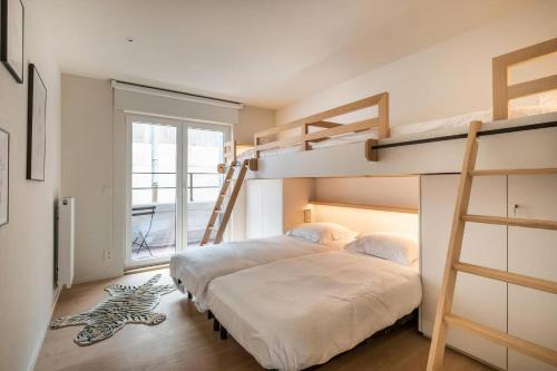 1 dormitorio con 2 literas y escalera en - Jacques-Annie - Fully renovated magnificent apt 50m from the beach, en Koksijde