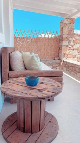 a wooden coffee table with a couch and a blue bowl on it at Sorokos Villa Panagia beach in Andiparos