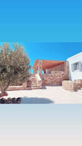 two views of a house with a brick wall at Sorokos Villa Panagia beach in Andiparos