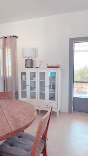 a dining room with a table and a white cabinet at Sorokos Villa Panagia beach in Andiparos