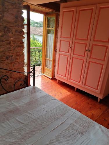 a bedroom with a bed and a large window at Large Stone Villa with garden. in Khánia