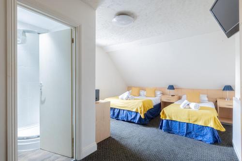 a room with two beds with yellow and blue sheets at Brooklands Lodge in Bournemouth