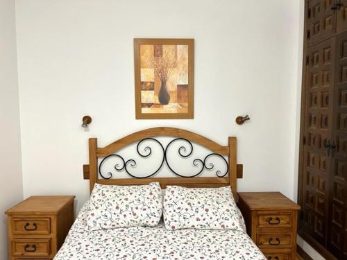 a bedroom with a bed with two night stands and a picture at Paradise in Aldea del Fresno