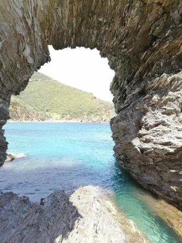 a cave in a rock wall next to a body of water at Large Stone Villa with garden. in Khánia