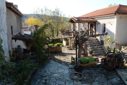 a small yard with a house and a tree at Giorgos' & Noula's Cottage in Desfina village- near Delphi in Dhesfína