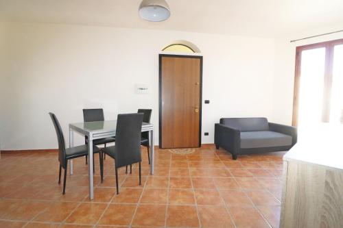 een eetkamer met een tafel en stoelen en een bank bij Casa Gelisuli in Girasole
