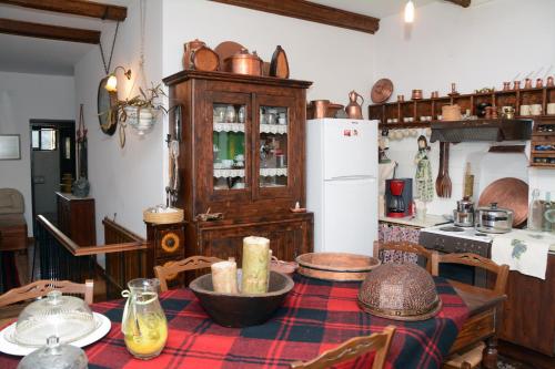 eine Küche mit einem Tisch und einem Kühlschrank in der Unterkunft Noula's and Giorgos' Cottage in Desfina village- near Delphi in Dhesfína