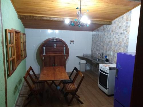 a kitchen with a table and chairs in a room at Pousada Lapralapa in Santana do Riacho