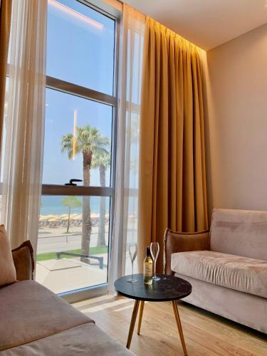 a living room with a couch and a table in front of a window at ELMAR HOTEL in Vlorë