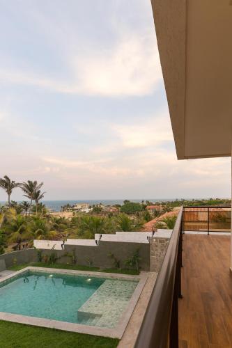 a view of a swimming pool from the balcony of a house at LUXURIOUS NEW HOUSE, UNFORGETABLE EXPERIENCE. in Canoa Quebrada