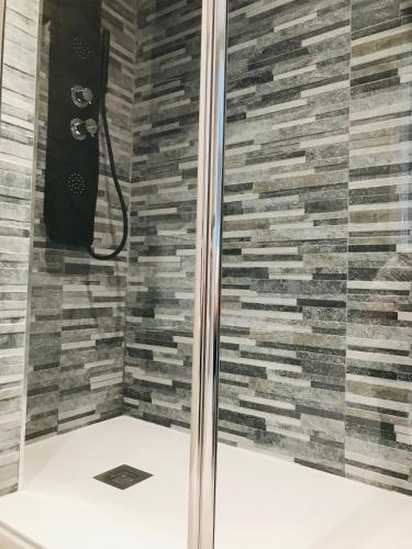 a shower in a bathroom with a stone wall at lucushouse III in Lugo