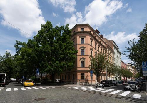 un bâtiment dans une rue avec des voitures garées devant dans l'établissement Bohemian Dreams Apartments and Suites by Dwellfort, à Prague