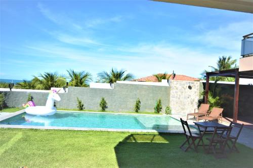 a swimming pool with a swan in a yard at LUXURIOUS NEW HOUSE, UNFORGETABLE EXPERIENCE. in Canoa Quebrada