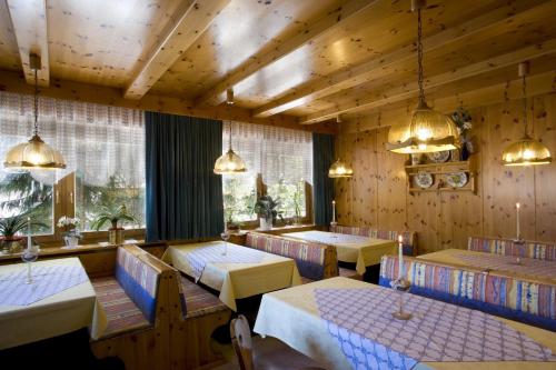 a dining room with tables and chairs and lights at Pensione Erica in Colfosco