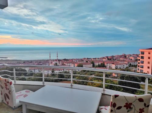 a balcony with a table and chairs and a view of the city at Bahardali Suites - شقق غصن الربيع in Trabzon