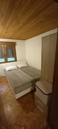 a bedroom with two beds and a wooden ceiling at Villa on the lake near Mostar in Jablanica