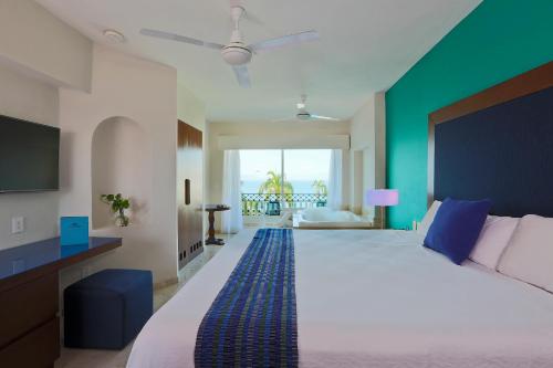 a bedroom with a large bed and a green wall at Crown Paradise Golden All Inclusive Resort - Adults Only in Puerto Vallarta