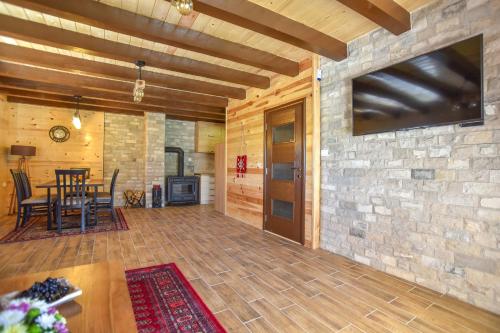 a living room with a table and a tv on a stone wall at Big bear villas in Žabljak