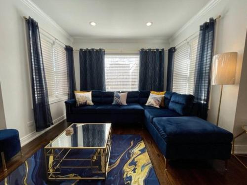 a living room with a blue couch and a glass table at The Blue Golden Luxury Modern 3- Bedroom Apartment in Chicago in Chicago