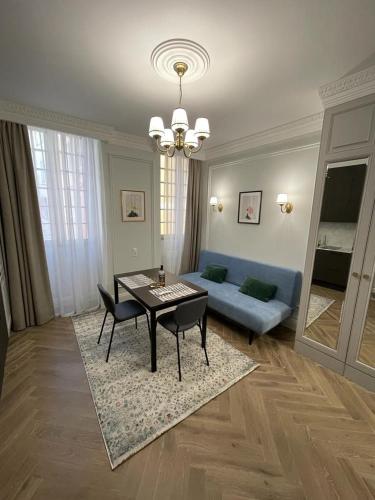 een woonkamer met een tafel en een blauwe bank bij Grand Studio Neuf in Villefranche-sur-Mer
