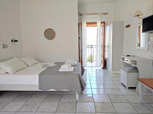 a white bedroom with a bed and a tiled floor at Emilia Apartments in Elounda