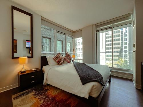 a bedroom with a large bed and a large window at Executive Hotel Cosmopolitan Toronto in Toronto