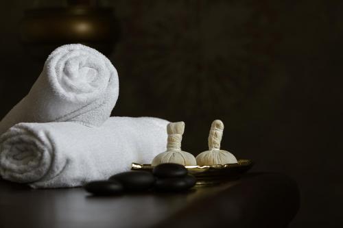 a towel and a plate with two candles and towels at Aroma Stone Hotel Spa in Syców