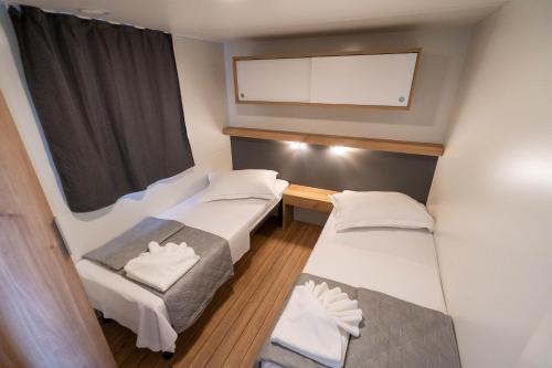 um pequeno quarto com duas camas e uma televisão em NEW !!! Adria Village Živogošće- camp Dole em Živogošće