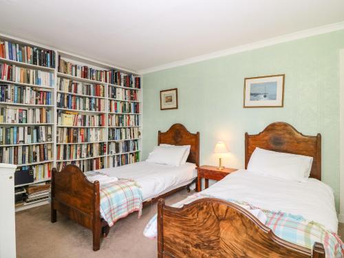 two beds in a room with bookshelves at Brae of Airlie Farm in Kirkton of Airlie