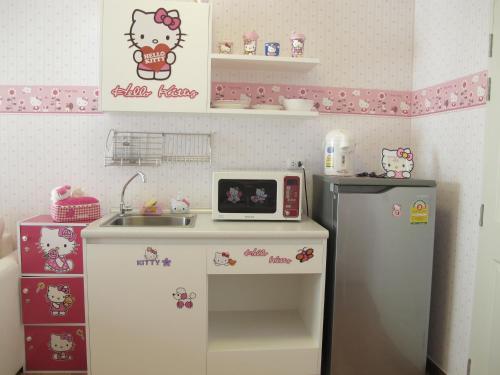 a small kitchen with a counter and a refrigerator at The Trust Hua Hin kitty room in Hua Hin