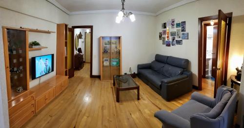 sala de estar con sofá y TV de pantalla plana en Donostia Vintage House en San Sebastián