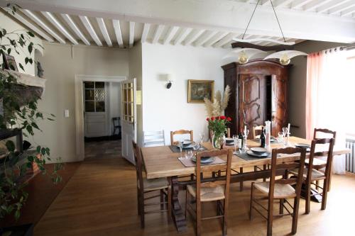 - une salle à manger avec une table et des chaises en bois dans l'établissement Un Jardin Secret, à Yzeron
