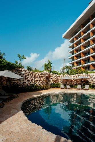 a swimming pool in front of a building at Secrets Moxché Playa del Carmen - Adults Only - All Inclusive in Playa del Carmen