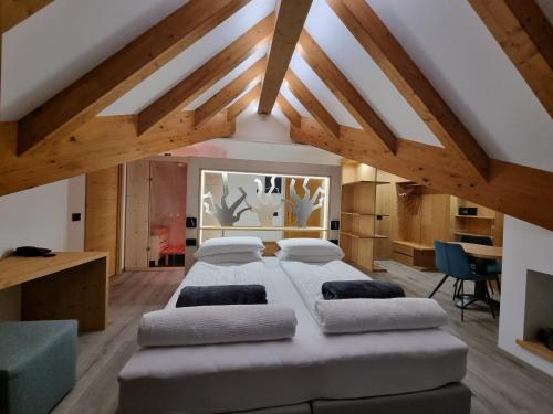 a bedroom with a large bed in a room with wooden ceilings at Hotel Canada in Andalo