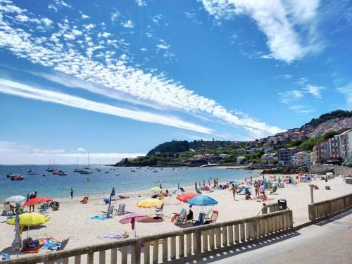 Grupa ludzi na plaży z parasolami w obiekcie Hotel Gran Proa Playa Raxó w mieście Raxo