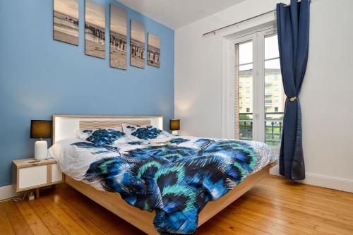 1 dormitorio con paredes azules y 1 cama con ventana en Le Fil Bleu - CENTRE VILLE - ENTIÈREMENT ÉQUIPÉ en Montluçon