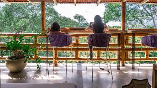 two women sitting in chairs on a porch looking out the window at La Veranda Hotel & Restaurant in Minca