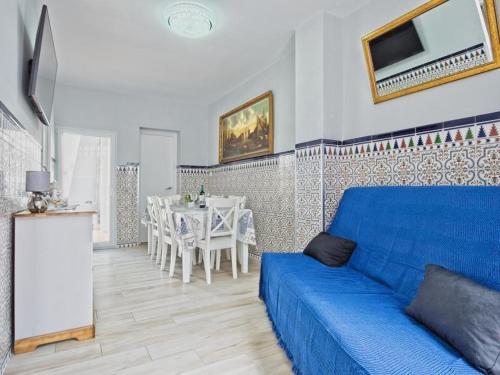 un soggiorno con divano blu e tavolo di CASA EN LA PLAYA VALENCIA EL PERELLO a Mareny Barraquetas