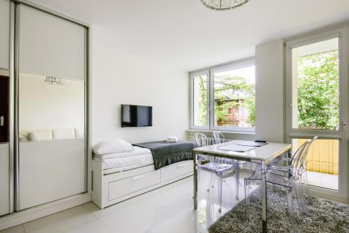 um quarto com uma cama, uma mesa e cadeiras em Sea You Apartments - Chrobrego em Sopot