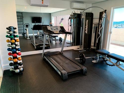 a gym with a treadmill and weights in a room at Paradiso Corporate in Cabo Frio