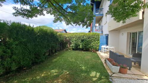 podwórko z trawnikiem i żywopłotem w obiekcie Appartement lumineux T3 avec jardin privatif à Hendaye - Parking et wif gratuit w mieście Hendaye