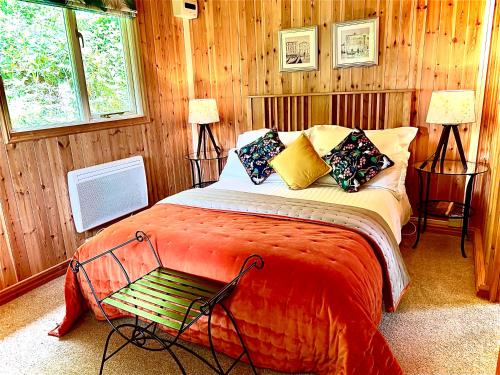 a bedroom with a bed with a red blanket at Treeside woodhouse in Hawkshead