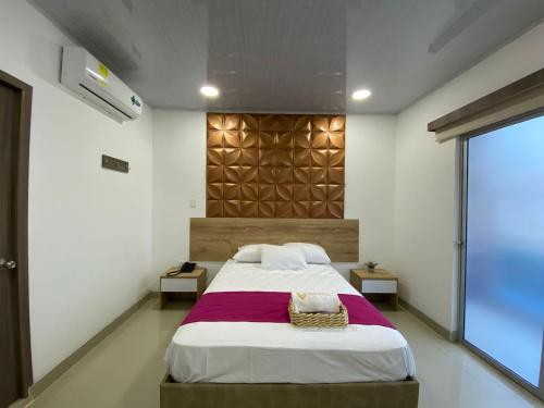 a bedroom with a large bed and a large window at HOTEL VIOLETTA Cereté in Cereté